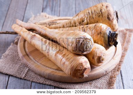 Parsnips on a wooden cutting board on a wooden table