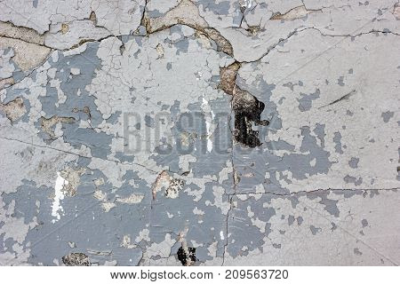Wheathered concrete wall with great number of cracks.