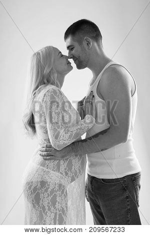 Beautiful pregnant couple in love on the background. Hands of husband on the tummy of his pregnant wife. Young man tenderly stroked pregnant belly of his wife. Husband kissing pregnant belly.