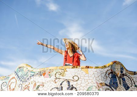 View on the beautiful terrace decorated with mosaic with happy woman tourist in Guell park in Barcelona