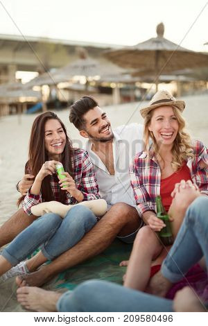 Group of young cheerful friends having great time at beach