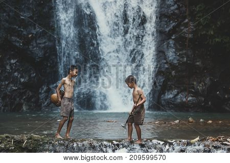 rural children are fishing at the river at forestChildren poverty living in countryside Vietnam are fishing at the river.