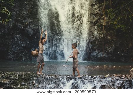 rural children are fishing at the river at forestChildren poverty living in countryside Vietnam are fishing at the river.