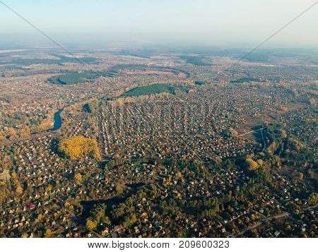 Aerial view on eastern Europe settlement in autumn noon light. Average rural view.
