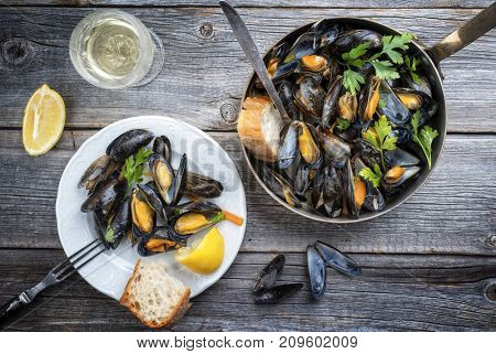 Traditional barbecue Italian blue mussel in white wine as top view in a casserole