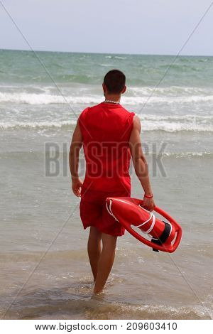 Muscular Lifeguard At Shore At The Sea Shore In The Beach