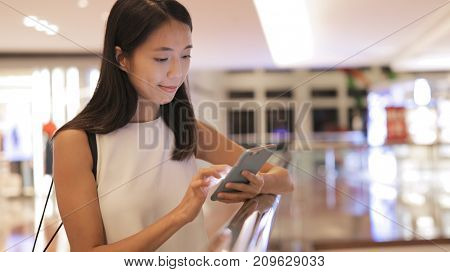 Woman using mobile phone in shopping center 