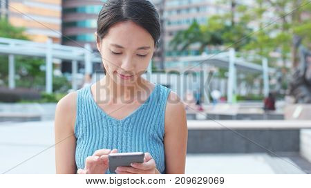 Woman working on cellphone at outdoor 