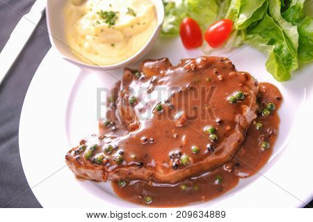 juicy beef steak in pepper sauce and salad