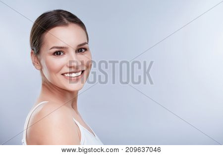 Beautiful smile white strong teeth. Head and shoulders of young woman with snow-white smile teethcare copyspace. Turned a little bit aside