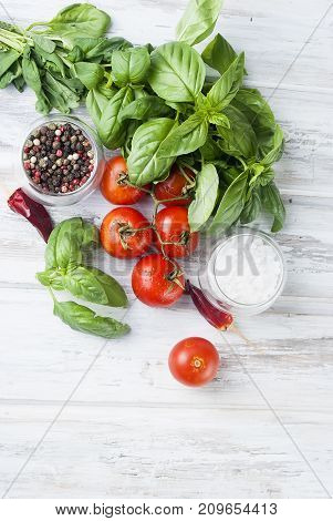 Tomatoes And Bunch Of Fresh Green Basil On A White Wood Background,