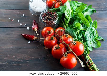 Tomatoes And Bunch Of Fresh Green Basil On A Dark Wood Background,