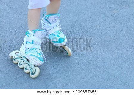 Legs of girl with white roller skates on asphalt outdoor noface