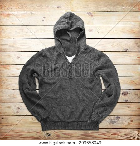 Grey jamper is over brown wood background