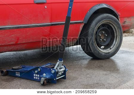 Part of car and tool for car repairing - levelling jack on asphalt outdoor