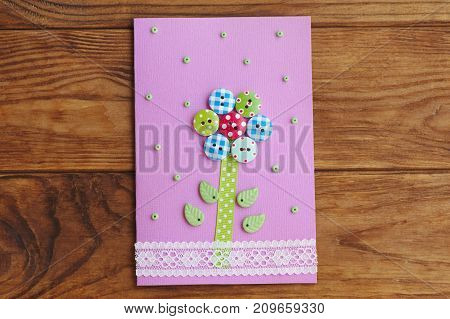 Nice greeting card isolated on a wooden background. Greeting paper card for happy birthday or mother's day or father's day. Easy paper craft work idea for kids. Top view