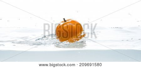 Whole, yellow and ripe tomato falls into the water. Water splashes. Isolated picture on white background