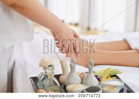Woman receiving professional feet massage in spa salon