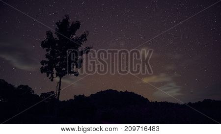 Long exposure and High ISO shot of star and milky way over the mountain at night. red tone effect.