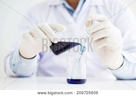 Scientists And Scientific Equipment Pouring Mixing Reagents Liqiud Beaker,laboratory Research Chemis