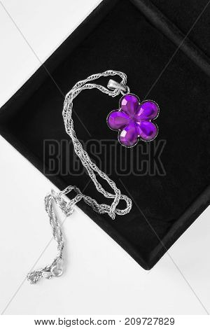 Purple amethyst flower pendant in black jewel box closeup