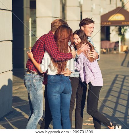 Meeting with old friend concept. Cheerful young people looking happy while having outdoor summer walk