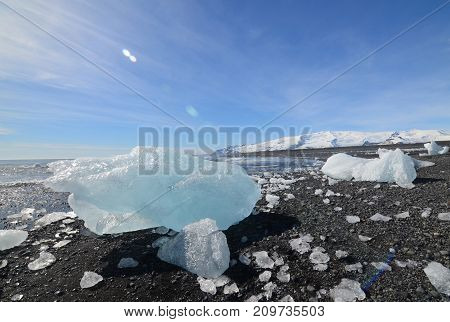 Glacial ice on the shore of a black sand beach