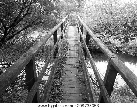 black and white image of a delapitated foot bridge