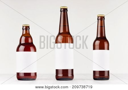 Brown beer bottles collection different type with blank white label on white wooden board mock up. Template for advertising design branding identity.