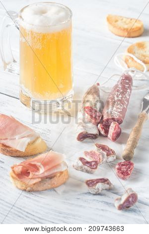 Mug of beer with sandwiches and smoked sausage