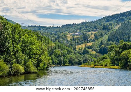 Summer mountain landscape. River and village in the mountains.