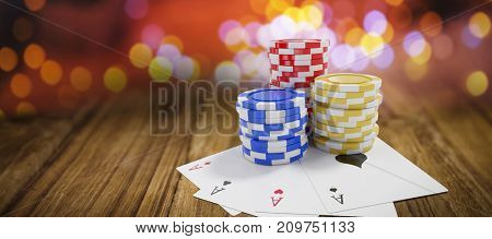 Tilt image of casino tokens with playing cards against wooden table