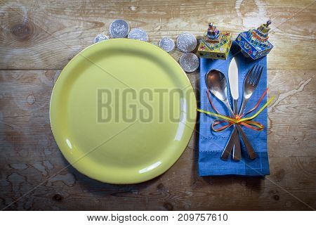 Casual country Hanukkah dinner place setting with colorful dreidels and gelt