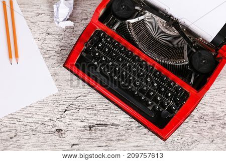 Vintage red typewriter maschine on the wooden table
