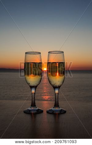 Two glasses of wine at sunset on the table.