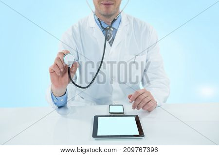 Doctor examining with 3D stethscope against blue vignette background