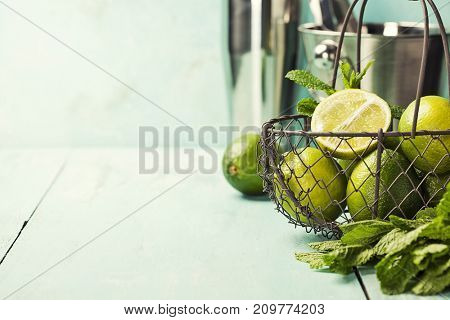 Mojito cocktail ingredients (fresh mint, lime, ice) on rustick background