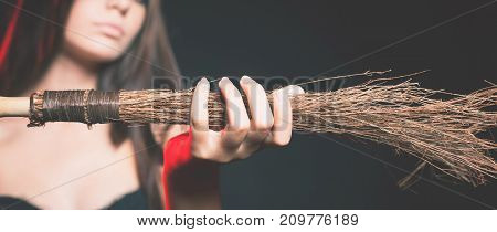 Closeup beautiful woman like witch holding broom. Fashion. Halloween costumes
