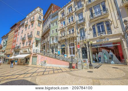 Coimbra, Portugal - August 14, 2017: people walk along pedestrian Rua Ferreira Borges in historic Coimbra, Portugal's most important university town and old capital. Baixa streets in medieval quarter.