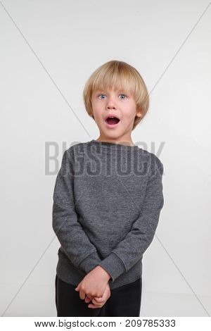 Cool vertical portrait of handsome happy child, photo on grey background