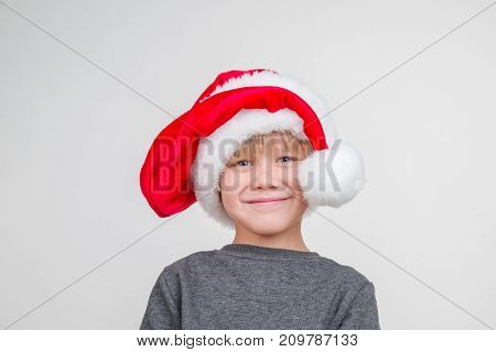 Emotional portrait of caucasian boy vith santa hat