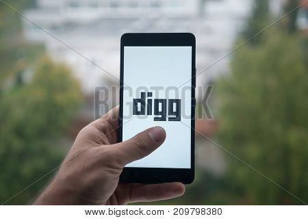 London, United Kingdom, october 3, 2017: Man holding smartphone with Digg logo with the finger on the screen