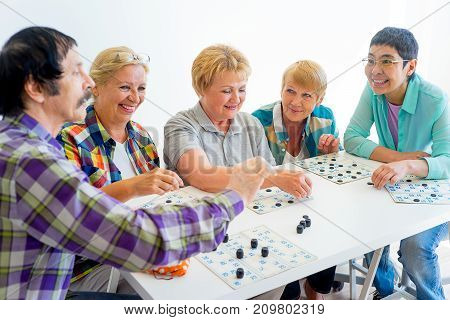 Group of elderly people playing bingo tigether