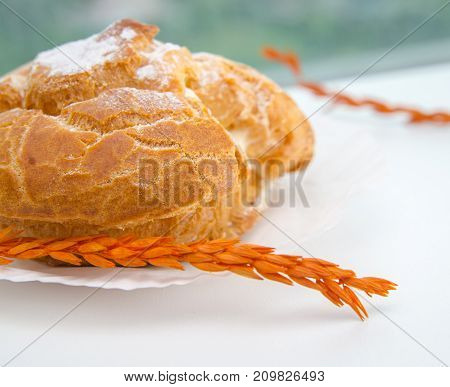 Profiteroles stuffed with pastry cream on white desk in cafe