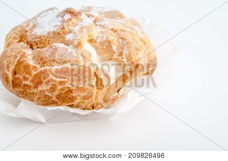 Profiteroles stuffed with pastry cream on white desk in cafe