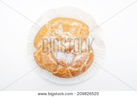 Profiteroles stuffed with pastry cream on white desk in cafe