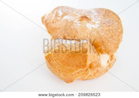 Profiteroles stuffed with pastry cream on white desk in cafe