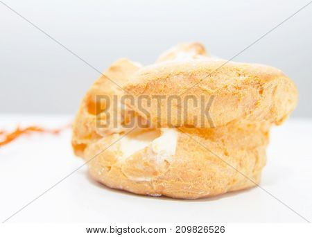 Profiteroles stuffed with pastry cream on white desk in cafe