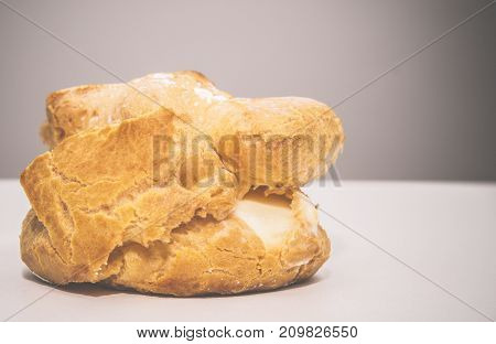Profiteroles stuffed with pastry cream on white desk in cafe