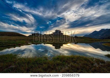 Mountain Landscape At Sunset Near An Alpine Hut